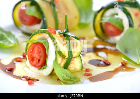 Caprese enveloppé de tranches de courgettes frites, attachés et noués avec la ciboulette, marinée à l'huile d'olive et vinaigre balsamique Banque D'Images