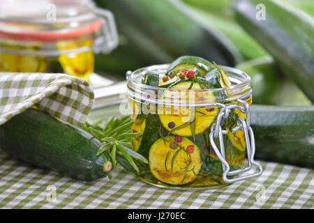 Poêlée de courgettes marinées dans l'huile d'olive avec des herbes et rempli dans un bocal de conserve Banque D'Images
