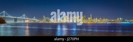 Classic vue panoramique sur les toits de San Francisco avec le célèbre Oakland Bay Bridge illuminée en beau crépuscule après le coucher du soleil en été Banque D'Images