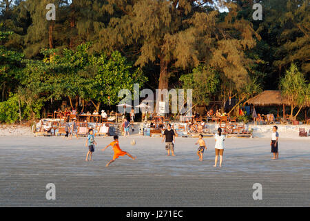 Enfants jouant au football en face de J.J. Restaurant de fruits de mer, Long Beach, Ao Yai, coucher de soleil, Koh Phayam, Thaïlande Banque D'Images