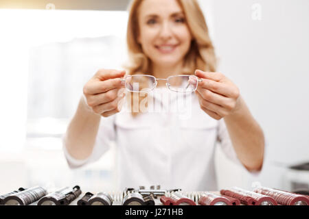 Joli gentil opticien suggère d'essayer sur des verres Banque D'Images