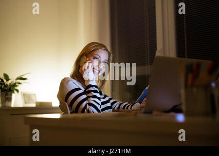 Femme avec ordinateur portable et smartphone, faire appel. Banque D'Images