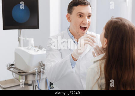 ENT heureux médecin examinant des maux de gorge Banque D'Images