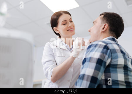 Smiling doctor examining maux de gorge Banque D'Images