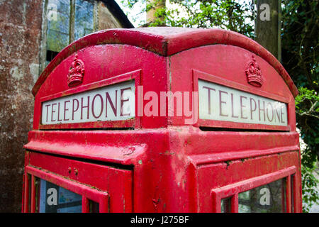 Le signe et le toit d'un rouge traditionnel britannique Londres cabine téléphonique ou stand dans close up. Banque D'Images