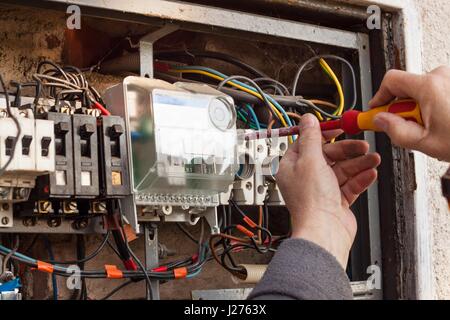 La réparation de vieux appareils de commutation électrique. Un électricien remplace l'ancien appareils électriques Banque D'Images