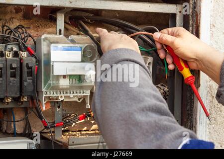 La réparation de vieux appareils de commutation électrique. Un électricien remplace l'ancien appareils électriques Banque D'Images