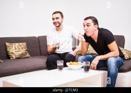 Friends enjoying soccer au plat avec des boissons et des collations Banque D'Images