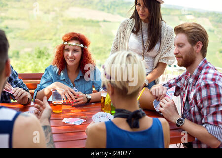 Les jeunes gais sont parfaitement s'amuser tandis que des boissons et de la bière joue dans la nature de la carte Banque D'Images