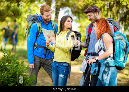 Sac à dos enfant marcheurs, à regarder la carte et la boussole en forêt Banque D'Images