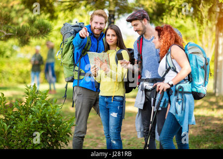 Les jeunes randonneurs regarder la carte et à la boussole pour l'orientation dans la nature Banque D'Images