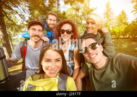 La photo en gros du groupe des jeunes gais dans la nature Banque D'Images