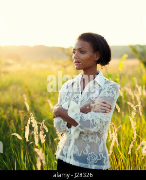 Belle jeune femme brune avec vitiligo maladie sur le terrain avec beau coucher de soleil Banque D'Images