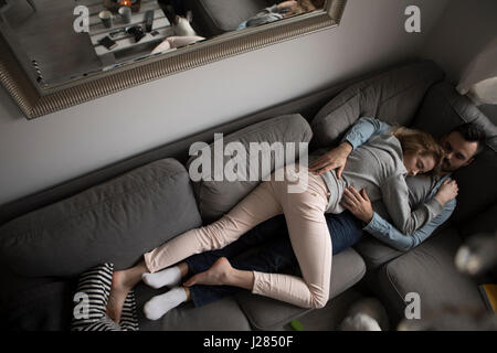 High angle view of couple on sofa at home Banque D'Images