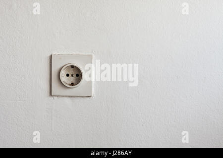 La texture d'un vieux mur blanc et bouchon électrique sur un côté. Banque D'Images