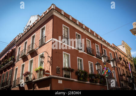 Vue latérale du beau rouge bâtiment rénové dans le centre-ville de Cagliari, Sardaigne, Italie. Bâtiment a nice petits balcons et plantes sur eux. Banque D'Images