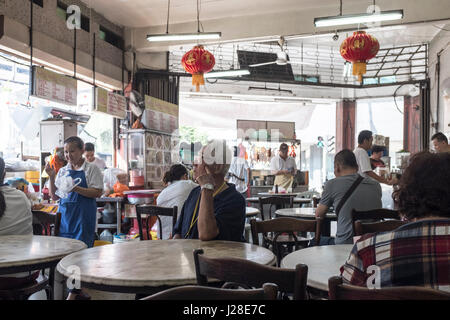 Un homme attend sa nourriture à un centre alimentaire à Kuala Lumpur, Malaisie Banque D'Images