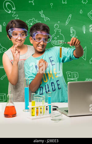 Les enfants indiens mignon faire de la science experiment in chemistry lab ou laboratoire de biologie à l'école Banque D'Images