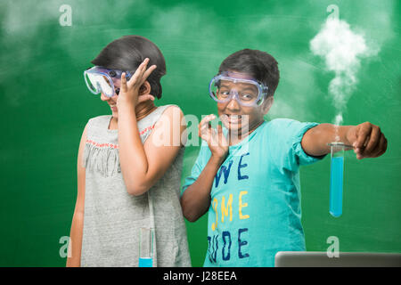 Les enfants indiens mignon faire de la science experiment in chemistry lab ou laboratoire de biologie à l'école Banque D'Images