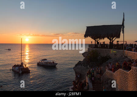 De la Jamaïque, Negril, Coucher du soleil à Rickś Café, les gens sont à la recherche de mesures à la mer au coucher du soleil Banque D'Images