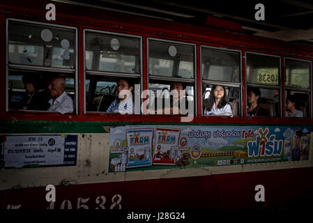 Femme dans un bus, prise dans un arbre de lumière, regardant par la fenêtre. Transports en commun de Bangkok Thaïlande, Banque D'Images