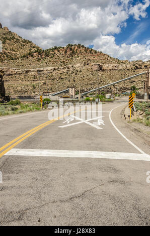 Grand panneau de passage à niveau du chemin de fer peint en blanc sur la route Banque D'Images