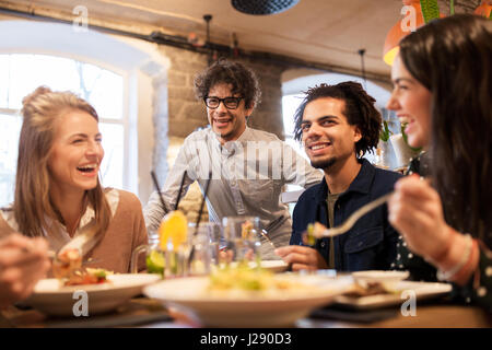 Heureux les amis boire et manger au restaurant Banque D'Images