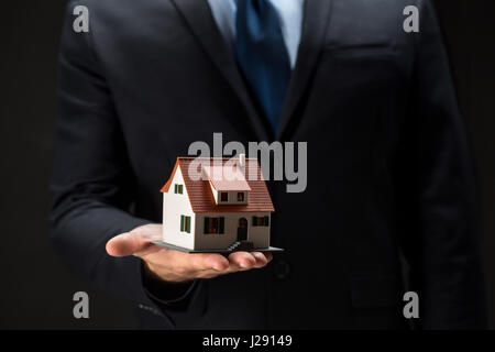 Close up of businessman holding house model Banque D'Images