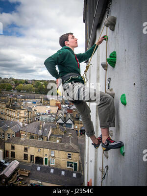 Grimpeur de l'équipe Go Luc Murphy sur le Royaume Uni à l'homme le plus haut mur d'escalade extérieur de l'avant de l'ouverture d'ROKTFACE dans le Yorkshire. Banque D'Images