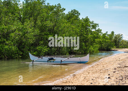 Ambatozavavy, Nosy Be, Madagascar - Le 19 décembre 2015 : pirogue en bois traditionnel avec outrigger sur la rive du village de pêcheurs sur l'île de Nosy Be Banque D'Images