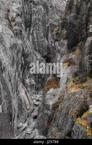 La rivière à sec en bas de montagne canyon entourée d'imposantes falaises de granit gris avec de la mousse et la végétation Banque D'Images