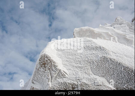 Des cristaux de glace et de givre de surface formé à partir de gel la nuit sur rocher en haute montagne en hiver contre en partie couvert de nuages ciel Banque D'Images