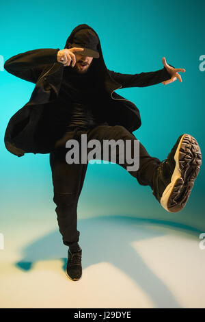 La silhouette d'un homme hip hop break dancer dancing sur fond coloré Banque D'Images