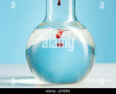 La verrerie de laboratoire et de liquide à l'intérieur rouge sur blanc Banque D'Images