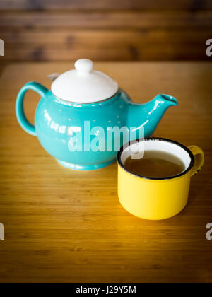 Une tasse de thé à la menthe jaune et une théière turquoise à la dérive Café-salon Vista et à Saskatoon, Saskatchewan, Canada. Banque D'Images