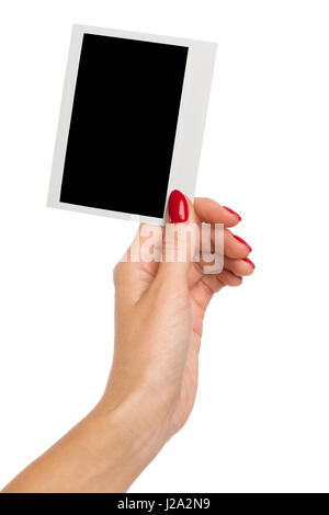 Close up of woman's hand with red nails holding blank polariod photo. Studio shot isolé sur blanc. Banque D'Images