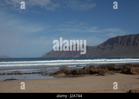 Les surfeurs attendent la vague parfaite à la plage de Famara, Lanzarote Banque D'Images
