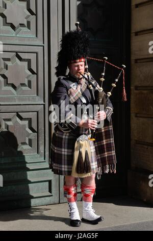 Un cornemuseur soliste en pleine Scottish regalia busks sur le Royal Mile, Édimbourg, Écosse, Royaume-Uni Banque D'Images