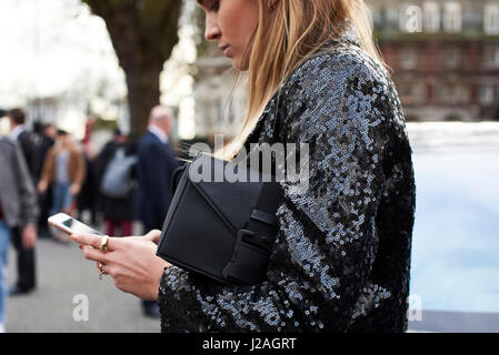 Londres - Février 2017 : Taille view of woman using smartphone en dehors de la rue Christopher Kane fashion show, London Fashion Week, jour 4. Banque D'Images