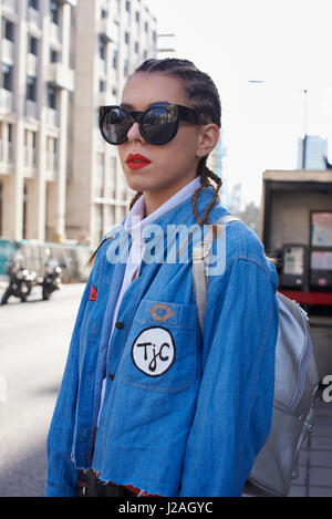 Londres - Février 2017 : Taille portrait de femme avec des rangs de maïs hairstyle portant des lunettes de soleil dans la grande rue, London Fashion Week, jour 4. Banque D'Images