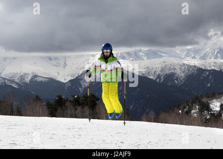 Jeune skieur saut avec bâtons de ski sur les montagnes et soleil nuageux ciel gris. Montagnes du Caucase. Hatsvali Svaneti, région de la Géorgie. Banque D'Images