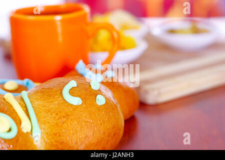 Configuration élégante de l'Amérique latine savoureux traditionnels pains de sucre coloré guagua, décorations, orange tasse avec colada morada jus de baies à côté de lui, le jour de la Dead concept Banque D'Images