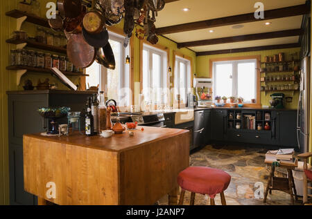 Hanging pots et casseroles sur un comptoir en bois table dans la cuisine à l'intérieur d'un pays modèle de petite maison Banque D'Images