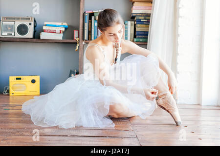 Chaussons de ballet danseuse attachant autour de sa cheville femme Ballerine pointe. Banque D'Images