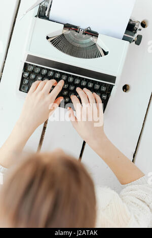 Woman's hand typing sur retro blanc machine. Banque D'Images