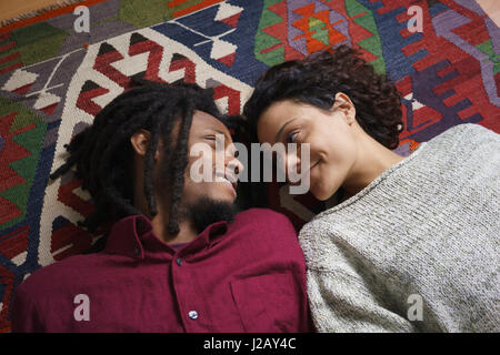 Affectueux de couple en position couchée sur un tapis Banque D'Images