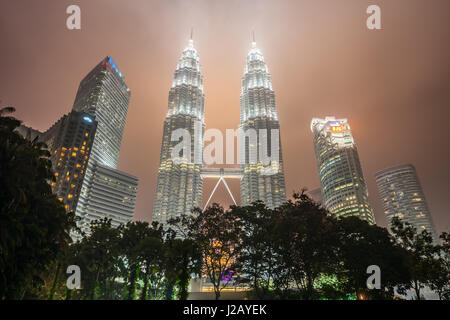 Les Tours Petronas à nuit brumeuse. Avec 452 mètres, les tours jumelles Petronas sont les plus hauts bâtiments jumeaux dans le monde. Kuala Lumpur, Malaisie. Banque D'Images