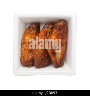 Ailettes de poulet frit dans un bol carré isolé sur fond blanc Banque D'Images