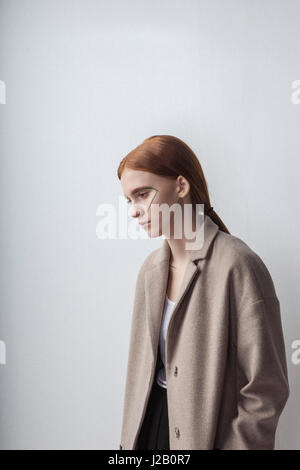 Thoughtful woman wearing jacket with face paint against white background Banque D'Images