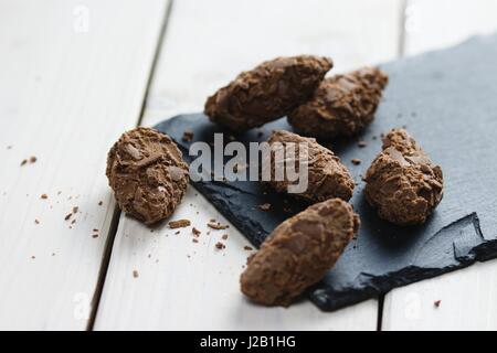 Pralines truffe au chocolat recouvert de copeaux de chocolat au lait sur ardoise servant d'administration et sur les tables en bois blanc Banque D'Images